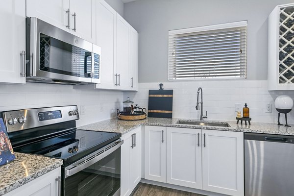 Modern kitchen with stainless steel appliances at The Gin Mill Apartments