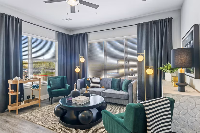 Modern living room with sleek furniture and large windows at The Gin Mill Apartments in a Greystar community