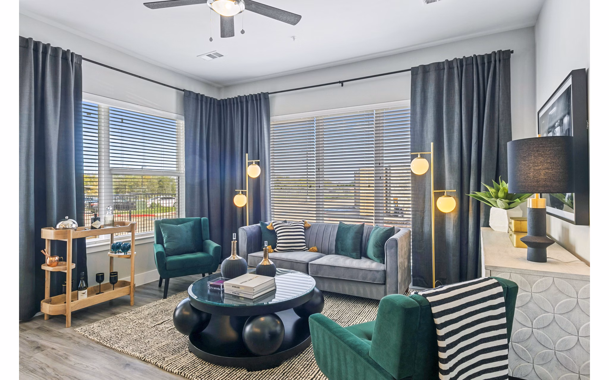 Modern living room with sleek furniture and large windows at The Gin Mill Apartments in a Greystar community