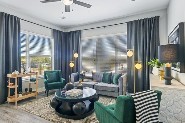 Modern living room with sleek furniture and large windows at The Gin Mill Apartments in a Greystar community