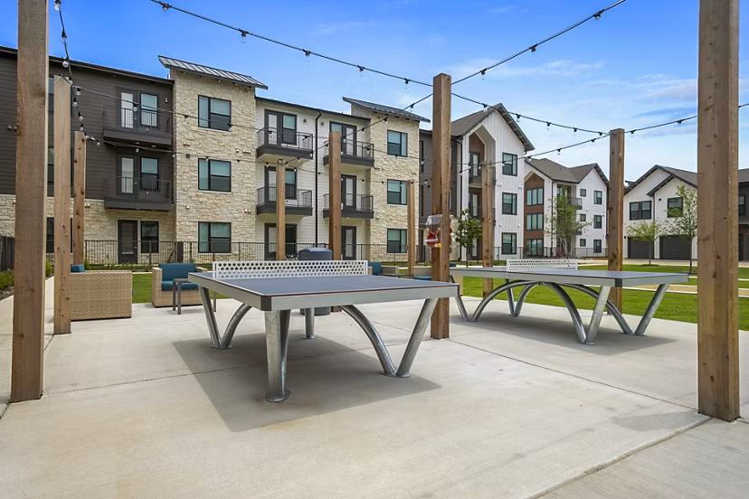 Outdoor recreational patio area with seating and garden views at The Gin Mill Apartments