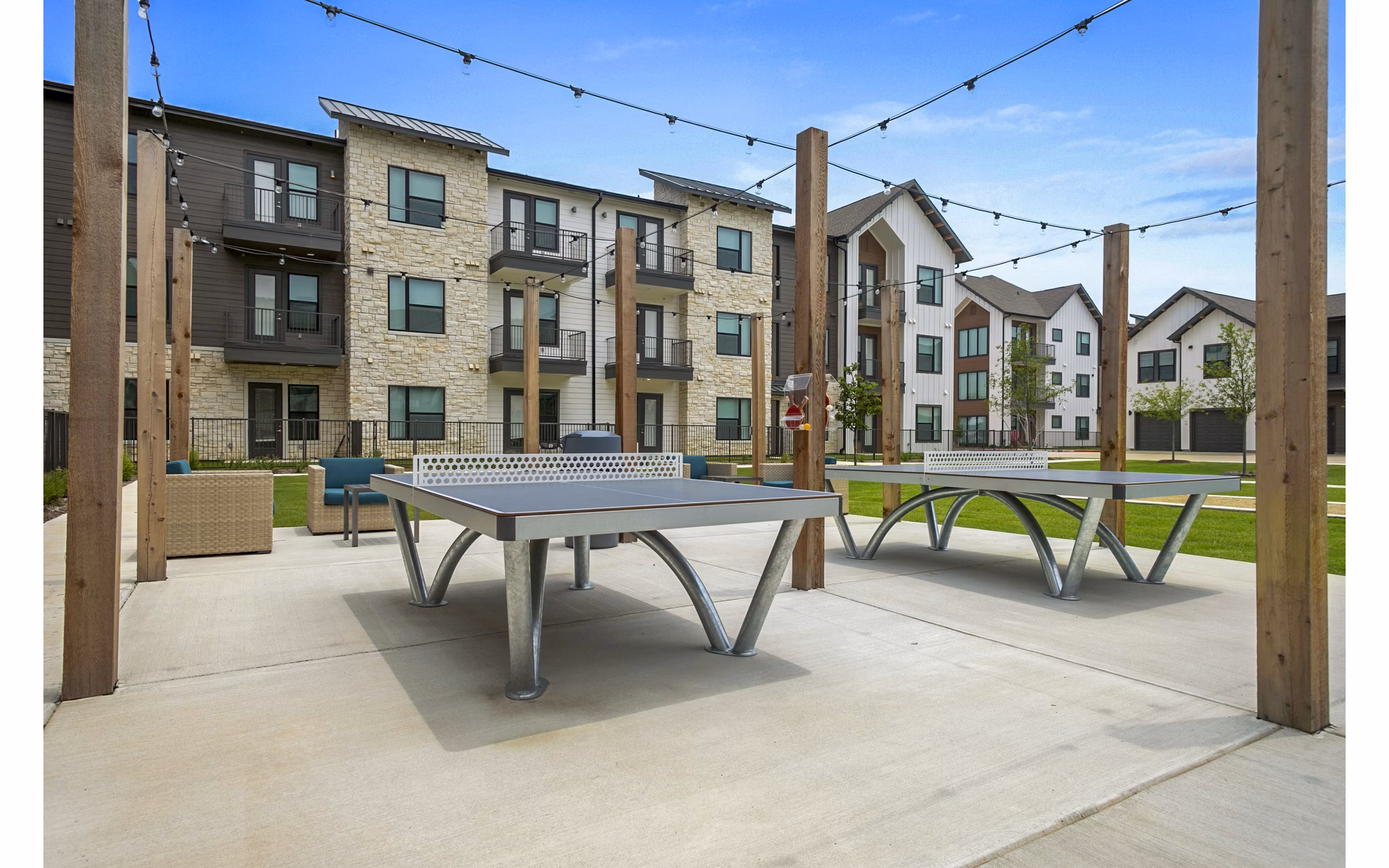 Outdoor recreational patio area with seating and garden views at The Gin Mill Apartments