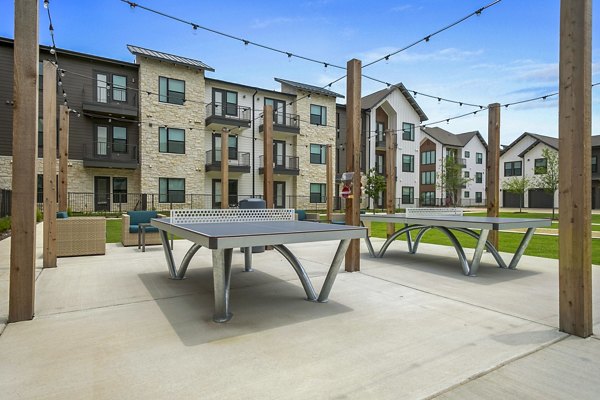 Outdoor recreational patio area with seating and garden views at The Gin Mill Apartments
