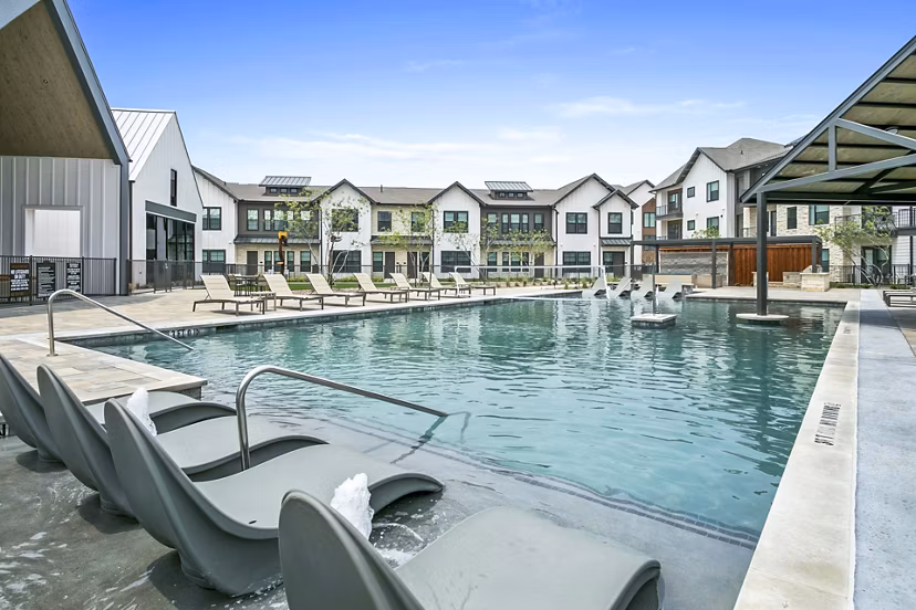 Modern pool with lounge seating at The Gin Mill Apartments