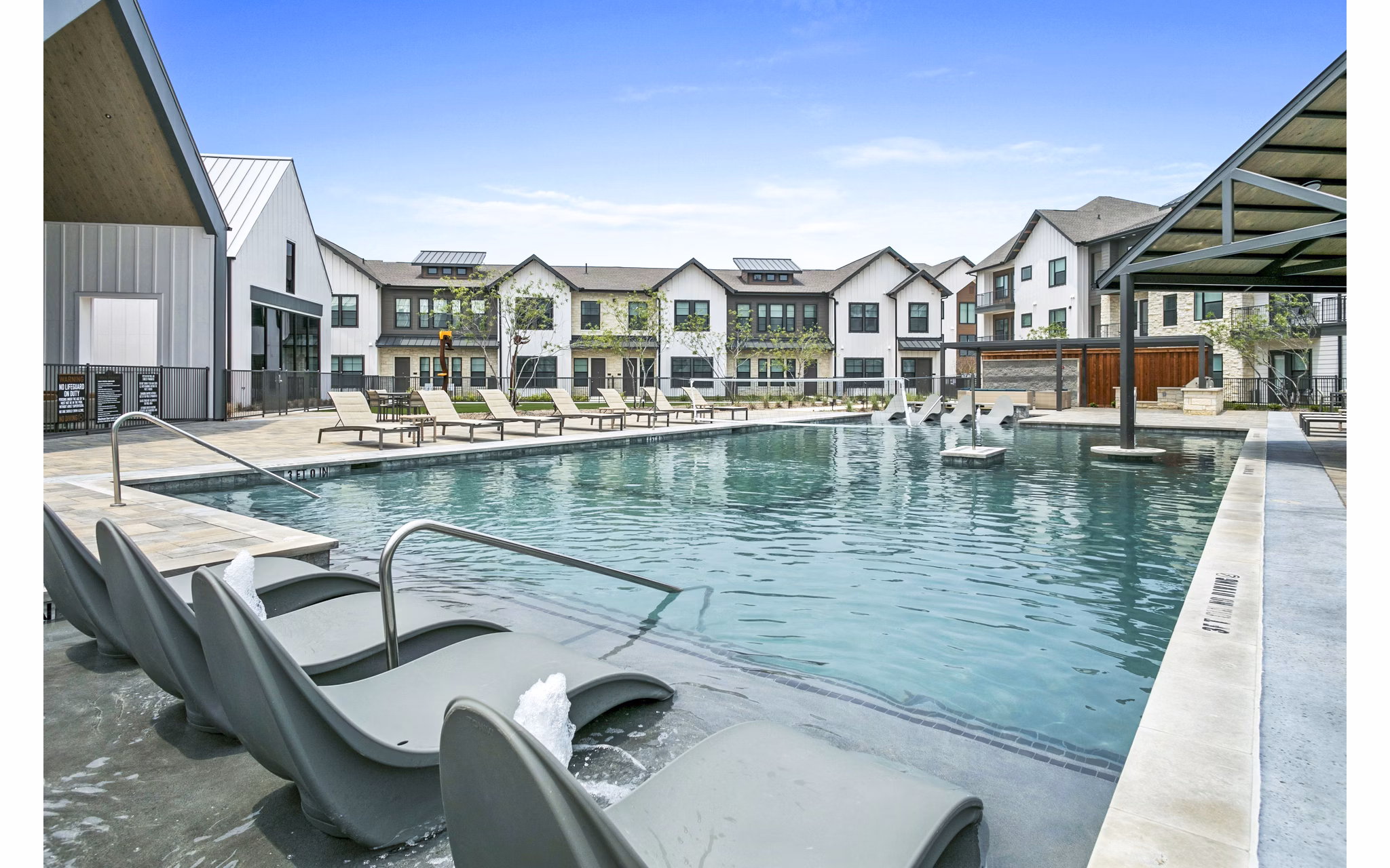 Modern pool with lounge seating at The Gin Mill Apartments