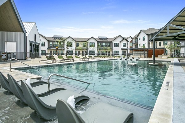 Modern pool with lounge seating at The Gin Mill Apartments