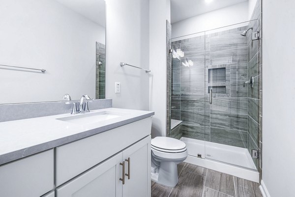 Modern bathroom with marble countertops and glass shower in Abode Kerr Ridge Apartments: luxury living by Greystar