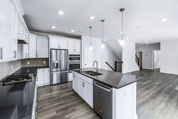 Modern kitchen with stainless steel appliances at Abode Kerr Ridge Apartments