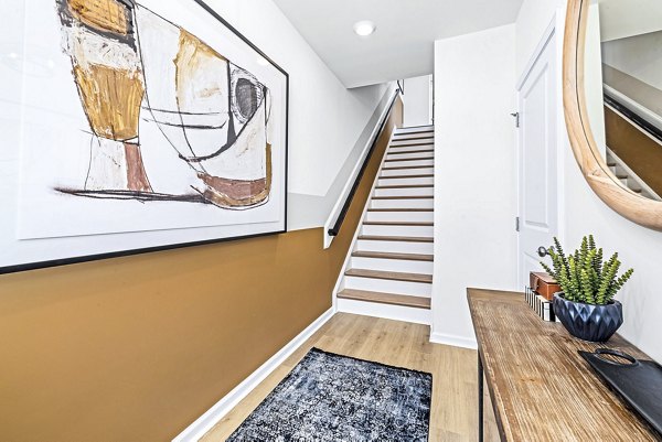 Hallway featuring stylish modern design with wooden stairs and elegant entry at Abode Kerr Ridge Townhomes