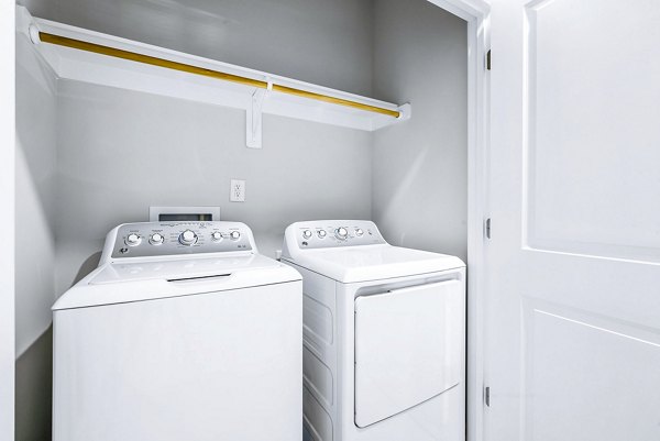 Laundry room featuring modern washers and dryers in Abode Kerr Ridge Apartments