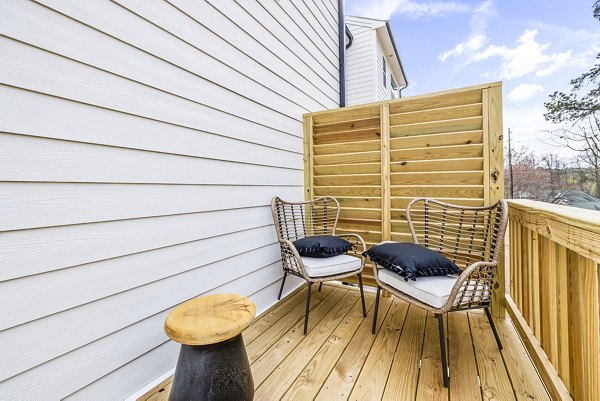 Relaxing patio with seating area at Abode Kerr Ridge Apartments, perfect for enjoying a peaceful afternoon outdoors