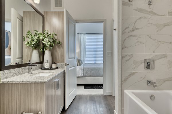 Modern bathroom with sleek fixtures and ample lighting at Park at Stone Oak Apartments