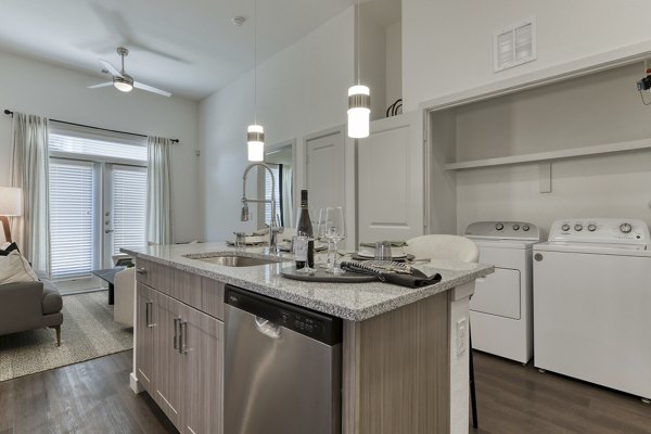 Modern kitchen with stainless steel appliances and granite countertops at Park at Stone Oak Apartments