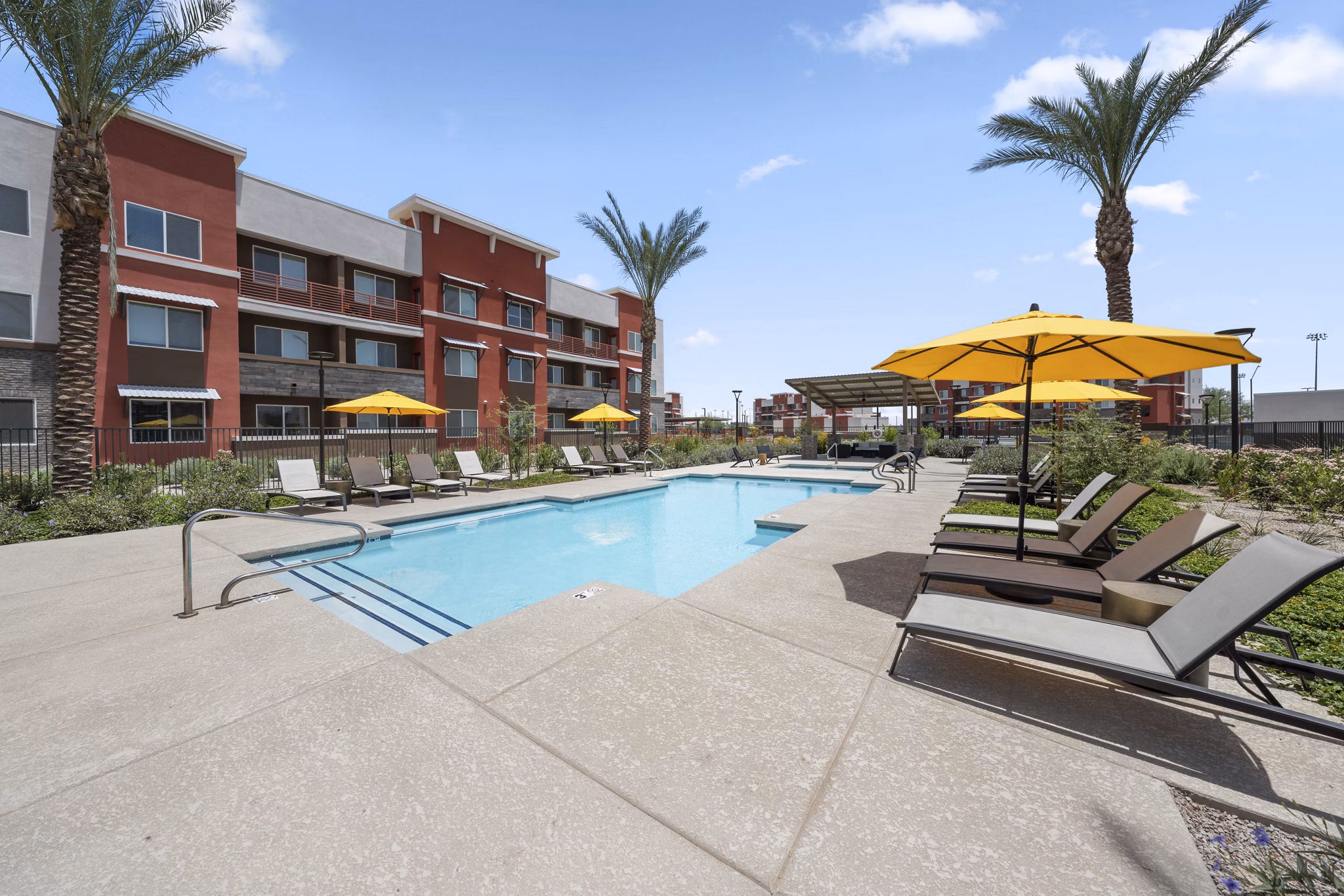 Resort-style pool with lounge chairs at Prose at Ballpark Village Apartments