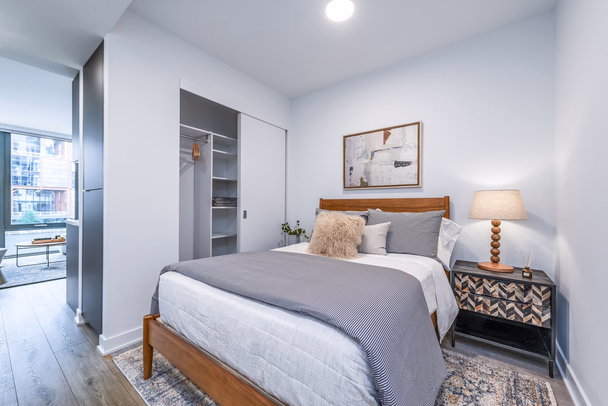 Modern bedroom featuring a spacious bed and stylish nightstand in luxury apartment