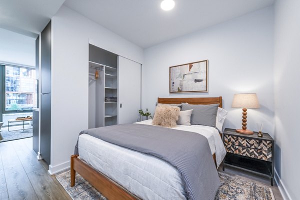 Modern bedroom featuring a spacious bed and stylish nightstand in luxury apartment