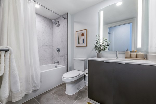 Modern bathroom featuring a sleek bathtub and stylish shower in luxury apartments