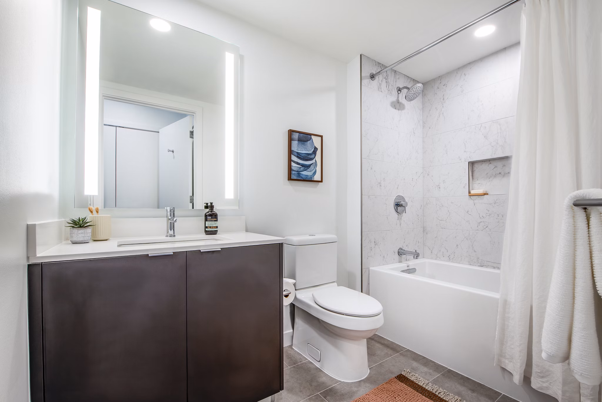 Modern bathroom with a sleek sink, mirror, and elegant tub in luxury apartments