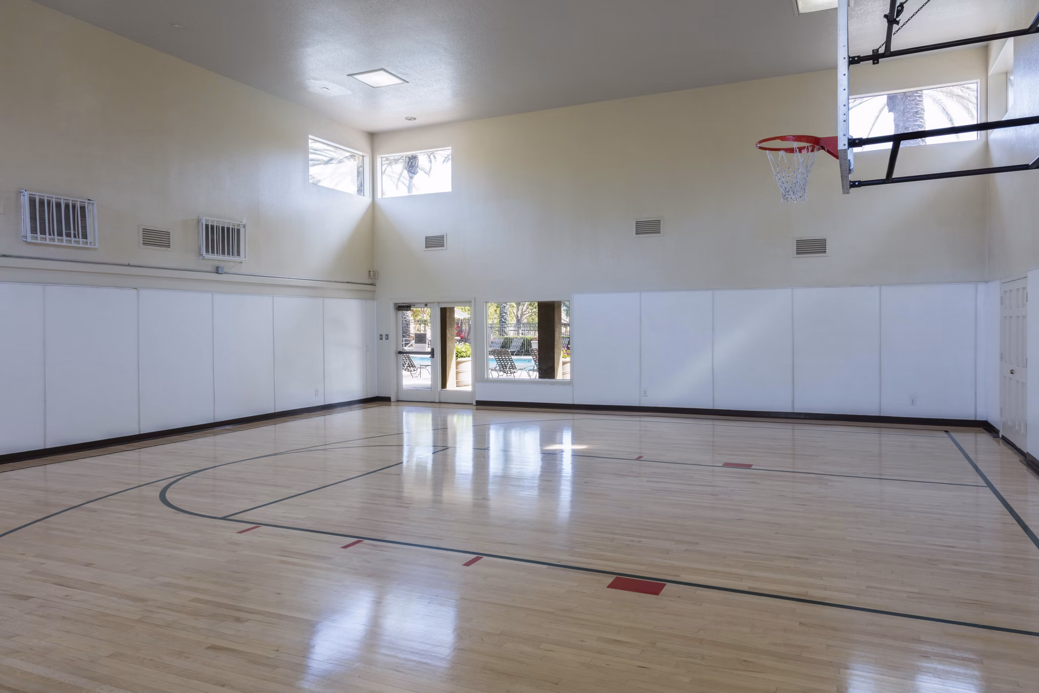Indoor basketball court with polished hardwood floors at Barcelona Apartments, perfect for recreational play and active living