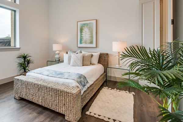 Cozy bedroom with modern decor featuring lush carpeting at The Mark at Denton Apartments