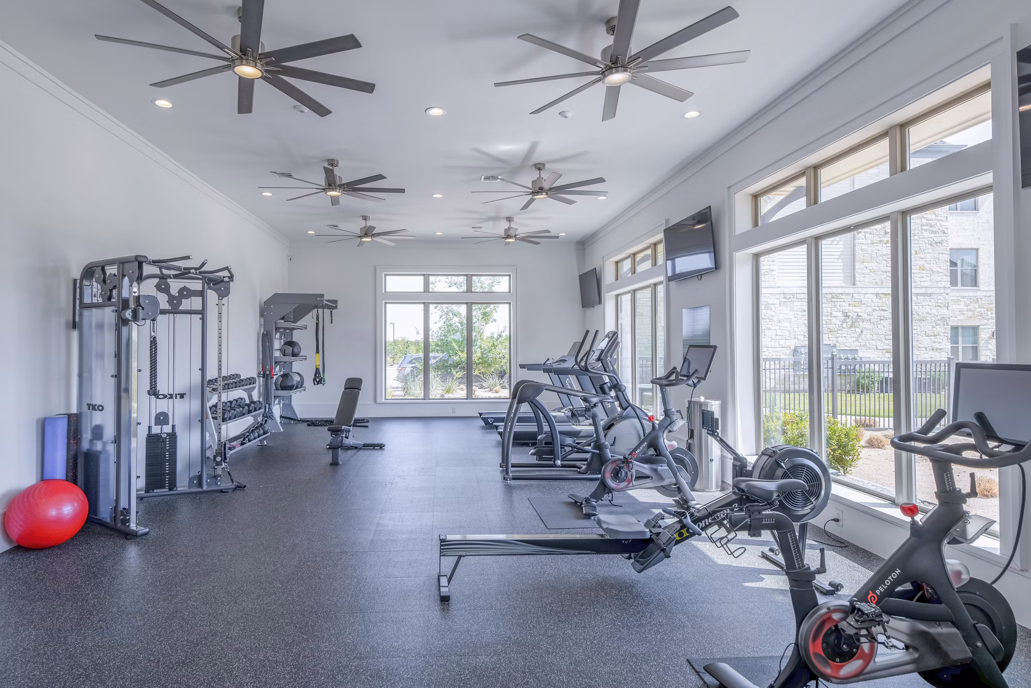 Modern fitness center with state-of-the-art equipment at The Beverley at Denton Apartments, offering a luxurious workout space