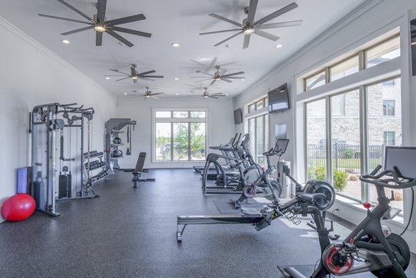 Modern fitness center with state-of-the-art equipment at The Beverley at Denton Apartments, offering a luxurious workout space