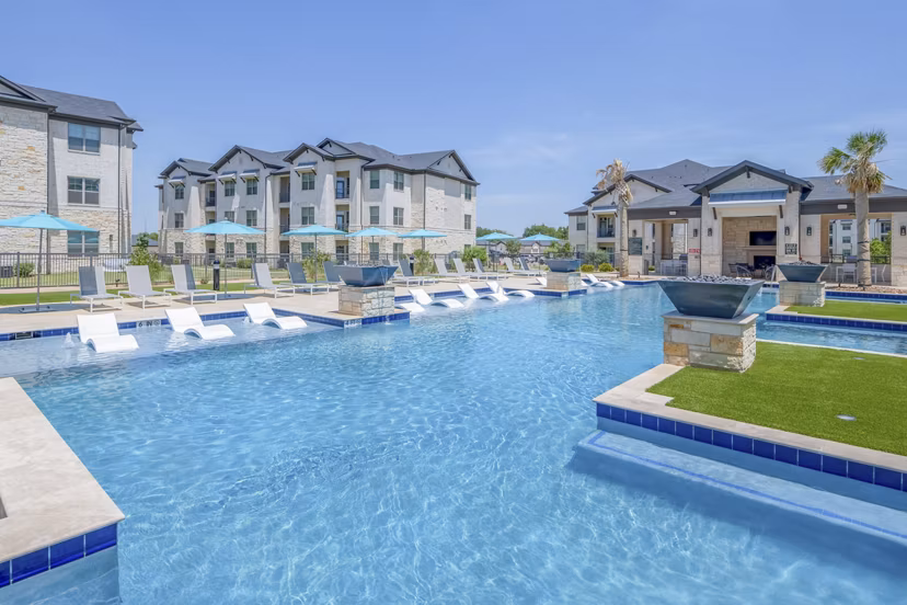 Resort-style pool with lounge chairs at The Mark at Denton Apartments, offering a luxury outdoor experience for residents