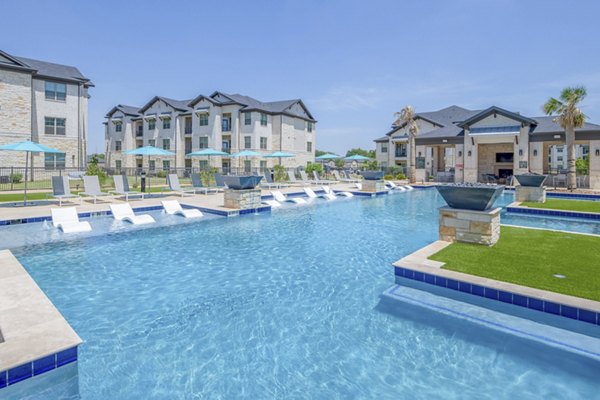 Resort-style pool with lounge chairs at The Mark at Denton Apartments, offering a luxury outdoor experience for residents