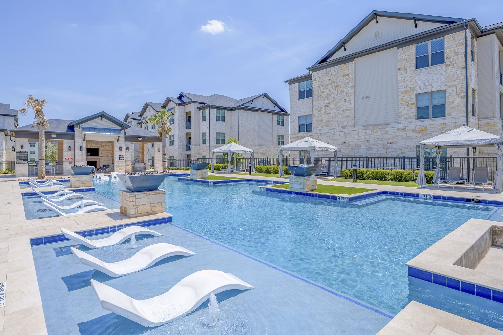 Resort-style pool with surrounding loungers at The Mark at Denton Apartments offering luxury living