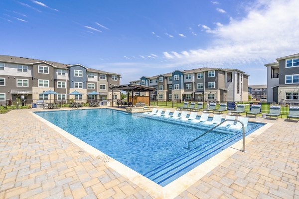 Resort-style pool at Prose Northbend Apartments with lounge chairs and lush landscaping for ultimate relaxation