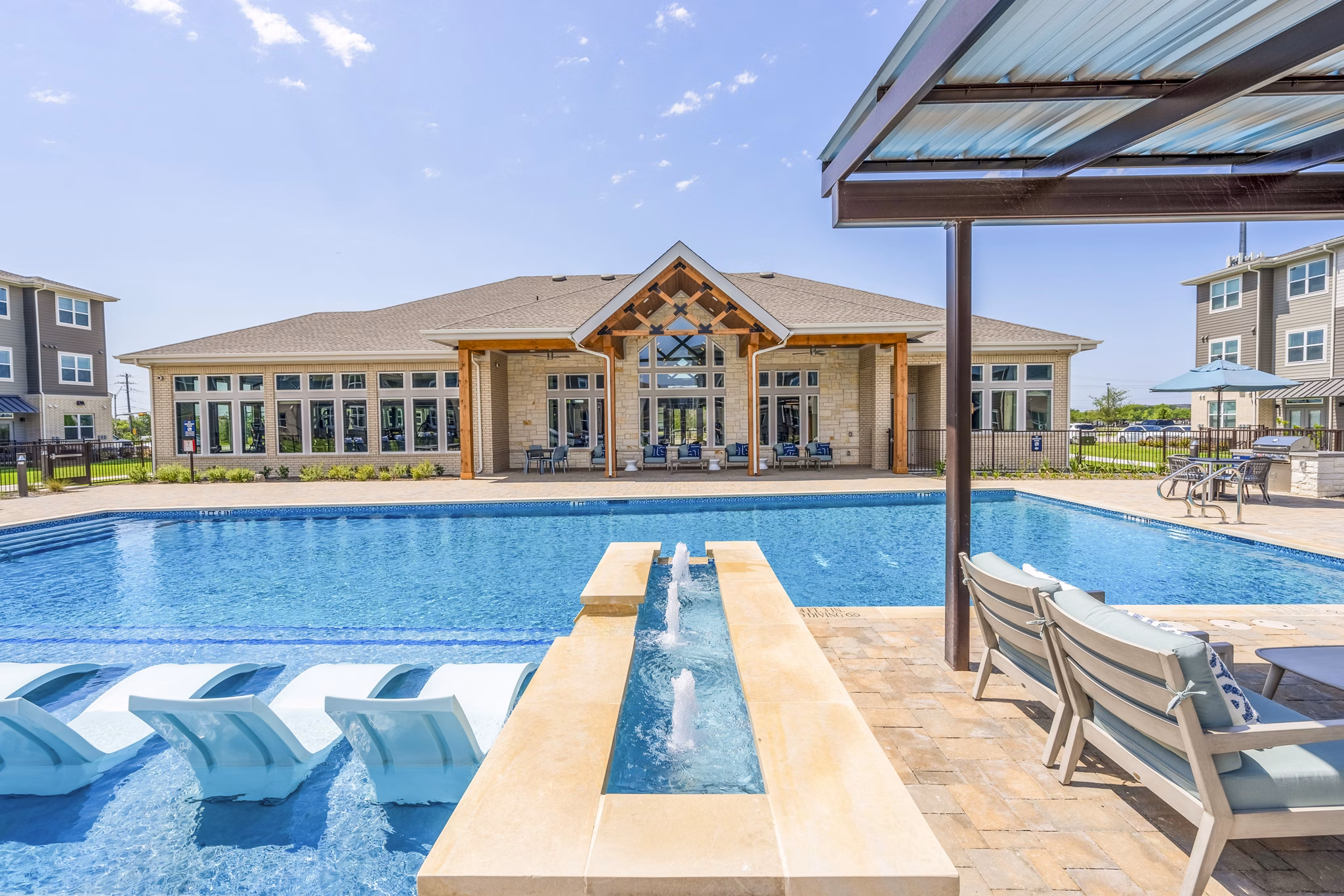 Resort-style swimming pool with lounge seating at Prose Northbend Apartments, offering a luxurious outdoor experience for residents