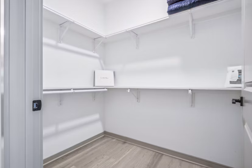 Bedroom closet featuring custom shelving and ample storage at Enclave at Raritan Apartments