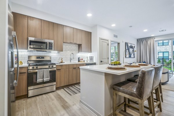 Modern kitchen with stainless steel appliances and granite countertops in Enclave at Raritan Apartments