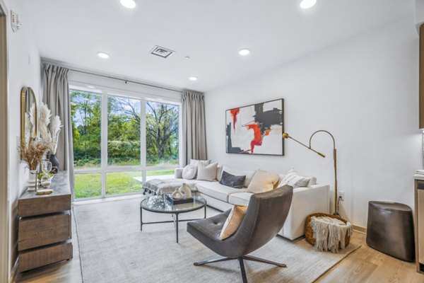 Modern living room with cozy furnishings and abundant natural light in Enclave at Raritan Apartments
