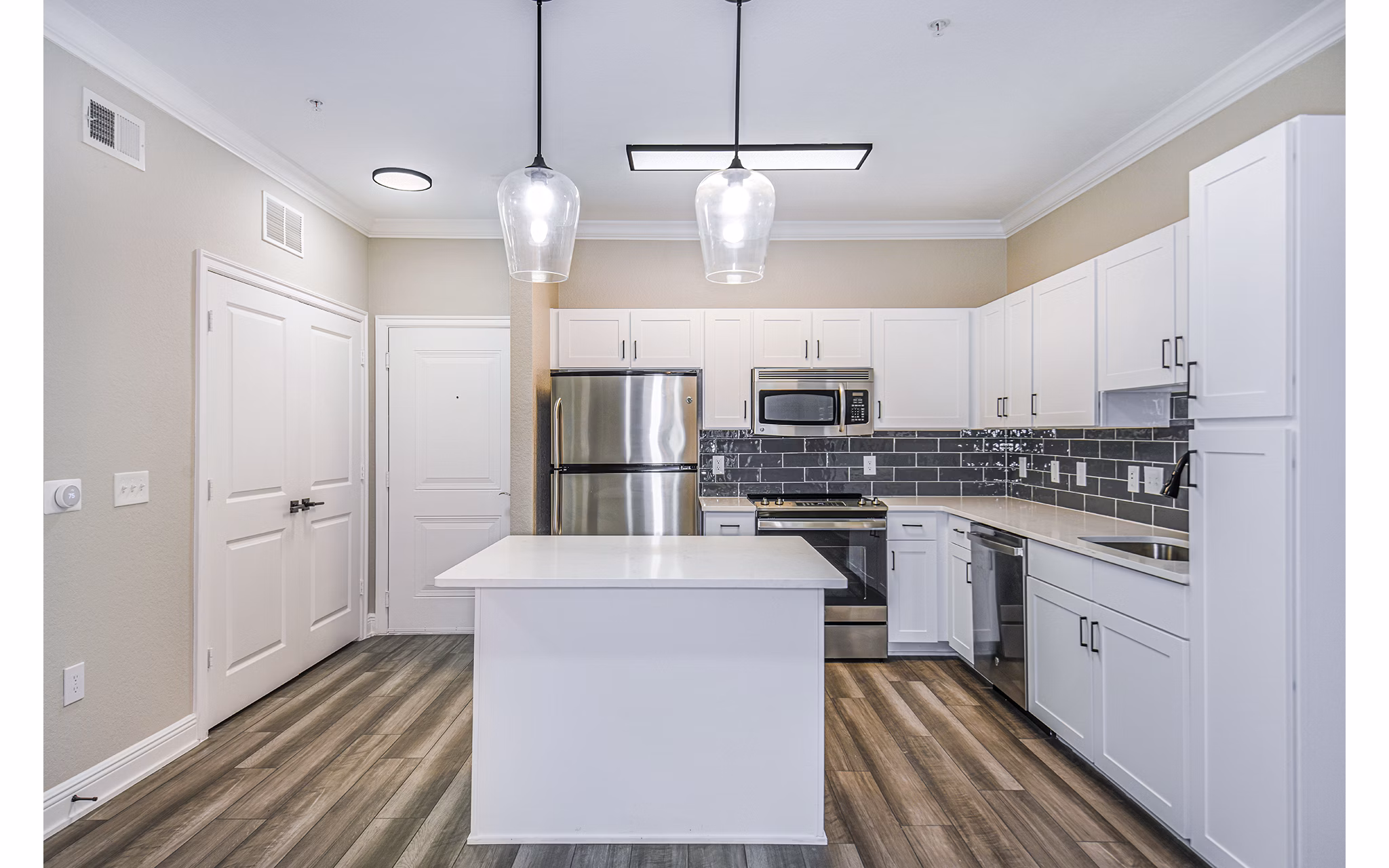 Modern kitchen with stainless steel appliances at The Village at Lake Lily Apartments