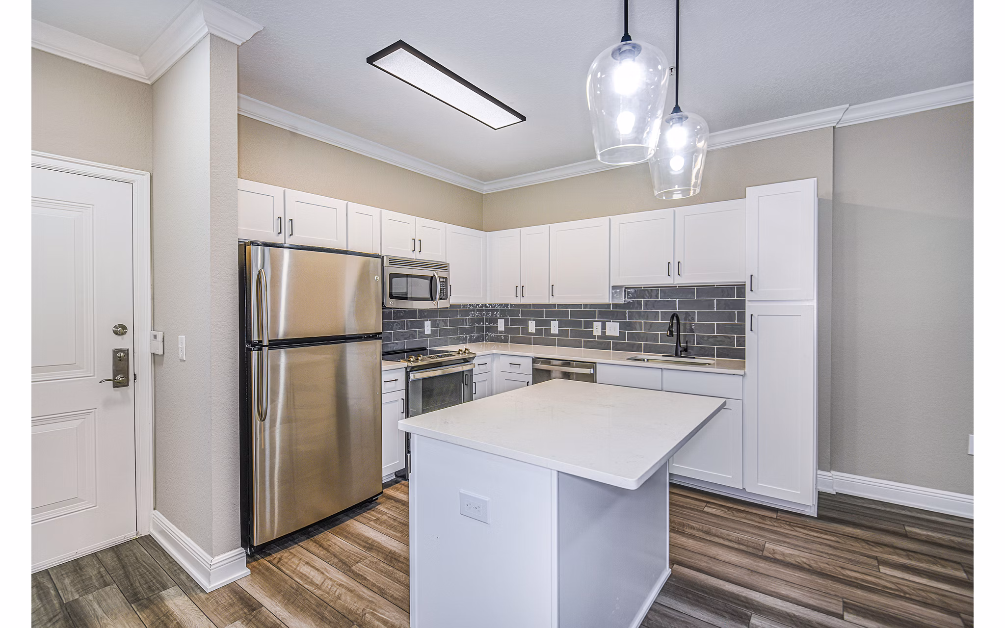Modern kitchen with stainless steel appliances at The Village at Lake Lily Apartments