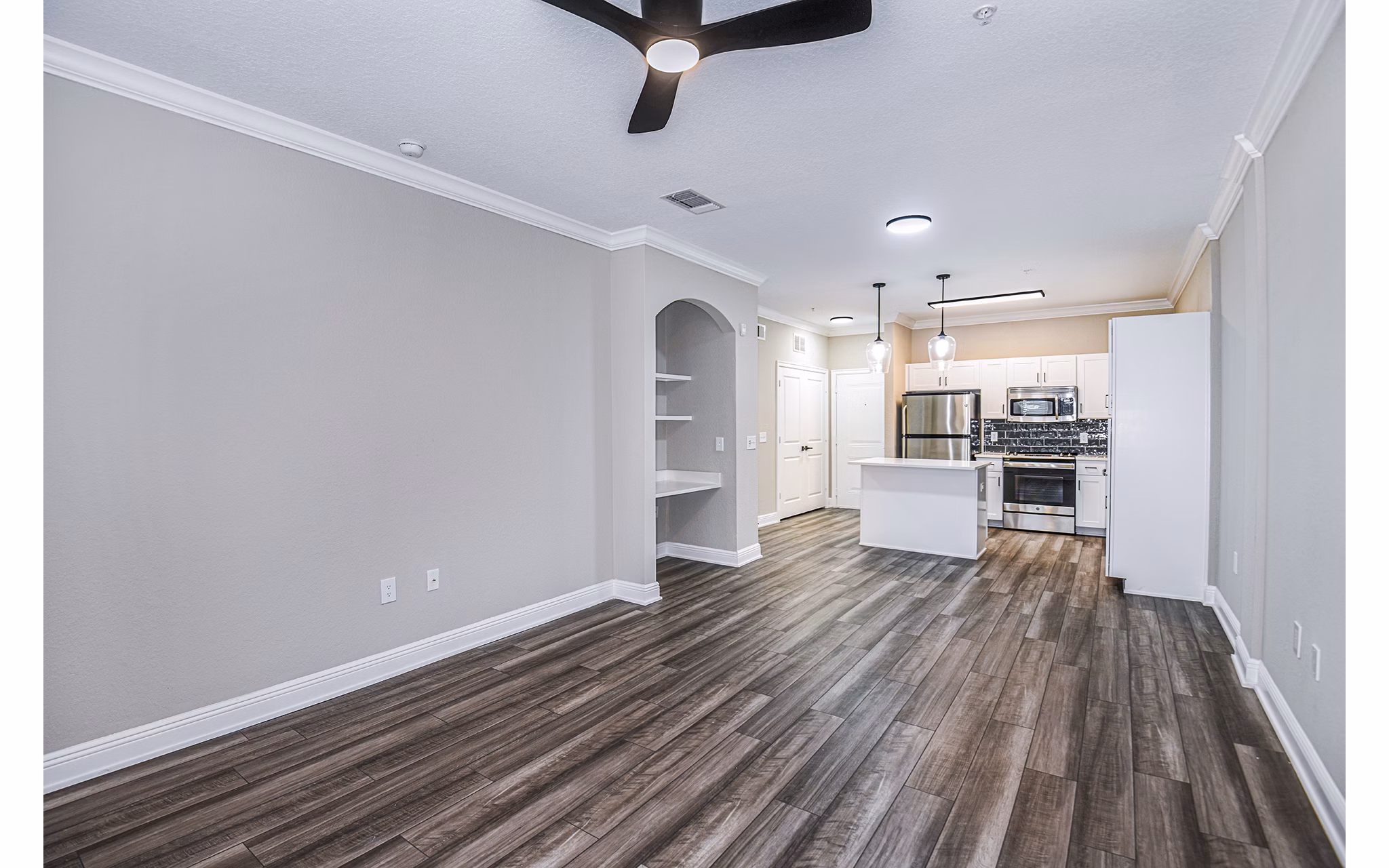 Contemporary living room featuring modern furnishings and large windows at The Village at Lake Lily Apartments