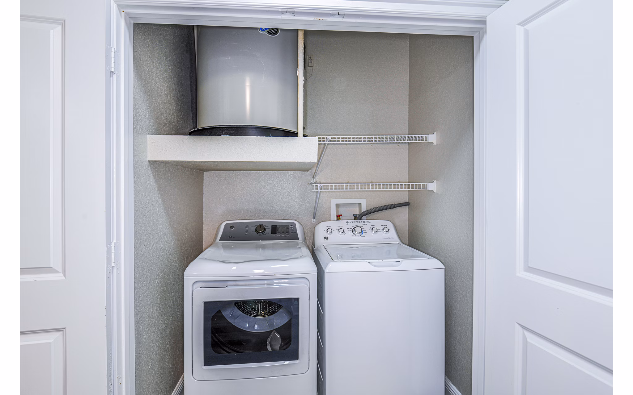 Laundry room with modern appliances at The Village at Lake Lily Apartments
