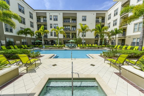 Relaxing poolside oasis at The Village at Lake Lily Apartments, offering luxury living and serene water features for residents