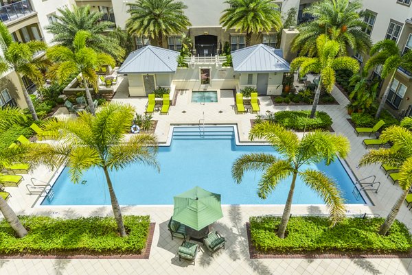 Sparkling swimming pool at The Village at Lake Lily Apartments, a Greystar luxury community in Maitland, featuring comfortable sun loungers and lush landscaping