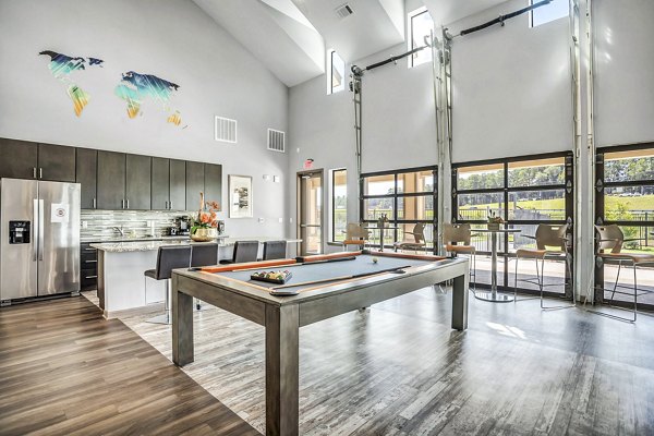 Clubhouse game room with pool table and lounge area at Haven at M Apartments for luxury living