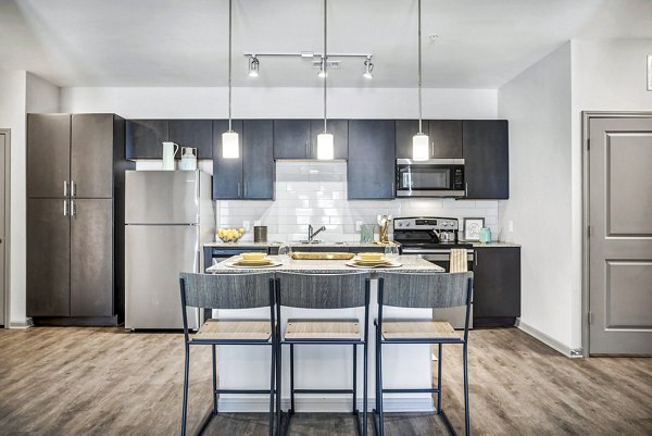 Dining room with modern kitchen appliances at Haven at M Apartments