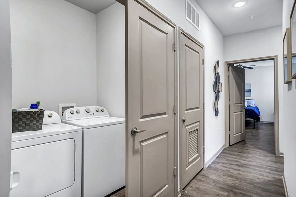 Laundry room featuring modern appliances at Haven at M Apartments