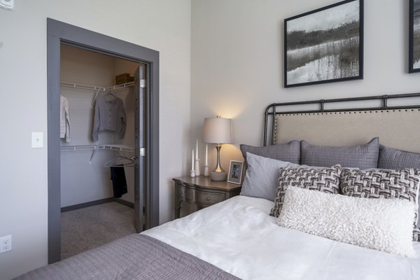 Cozy bedroom with modern decor at Sterling at Stonecrest Apartments: luxury living by Greystar