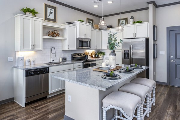 Modern kitchen with stainless steel appliances in Sterling at Stonecrest Apartments, featuring luxury finishes and ample counter space