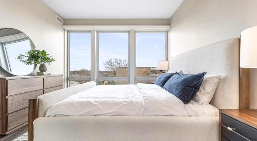 Bedroom featuring modern decor and ample natural light in District 1860 Apartments