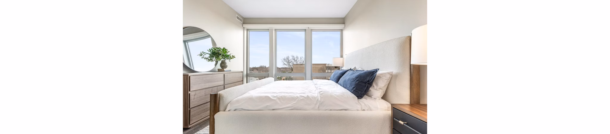 Bedroom featuring modern decor and ample natural light in District 1860 Apartments