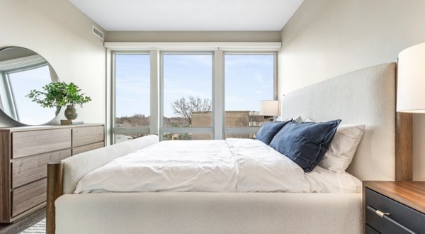 Bedroom featuring modern decor and ample natural light in District 1860 Apartments