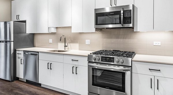 Open-concept kitchen with modern appliances at District 1860 Apartments