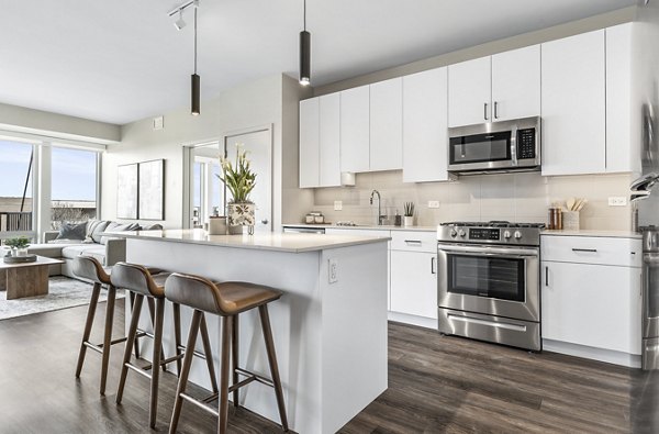 Modern living room with sleek furnishings and abundant natural light in District 1860 Apartments
